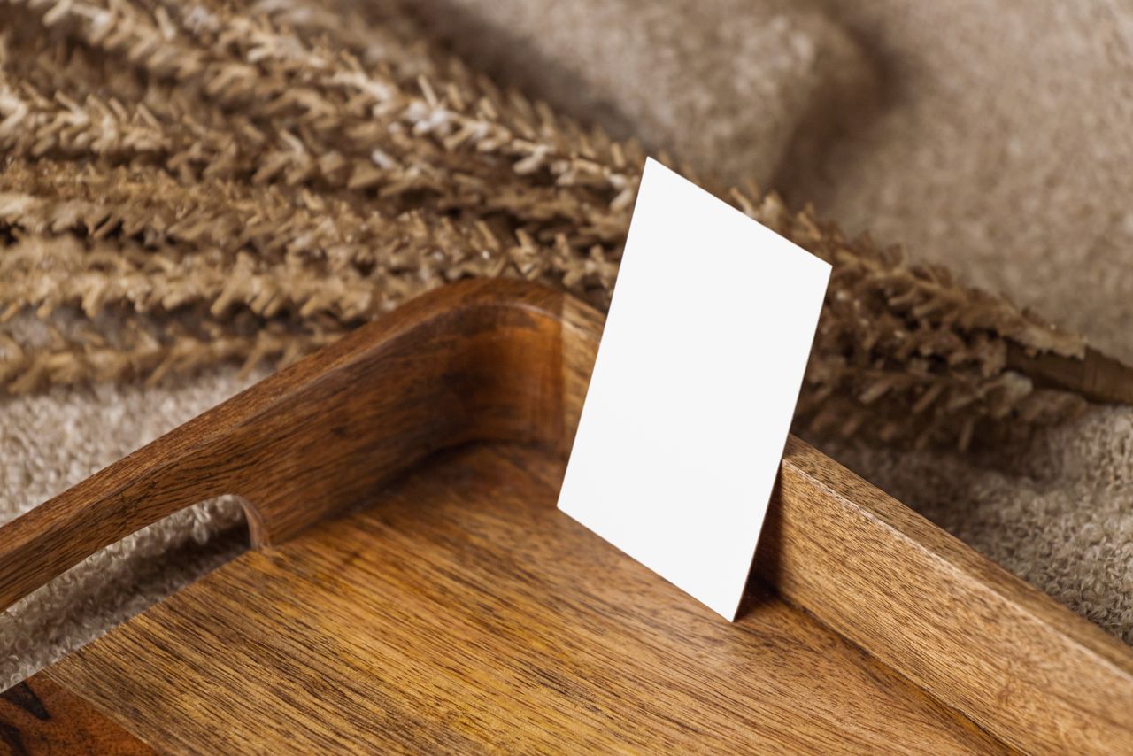 Blank business card on a wooden tray with dried wheat. Ideal for branding or design mockups.