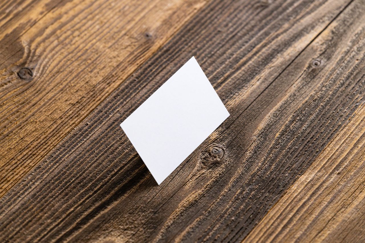 A blank card standing on a rustic wooden surface, ideal for mockups.