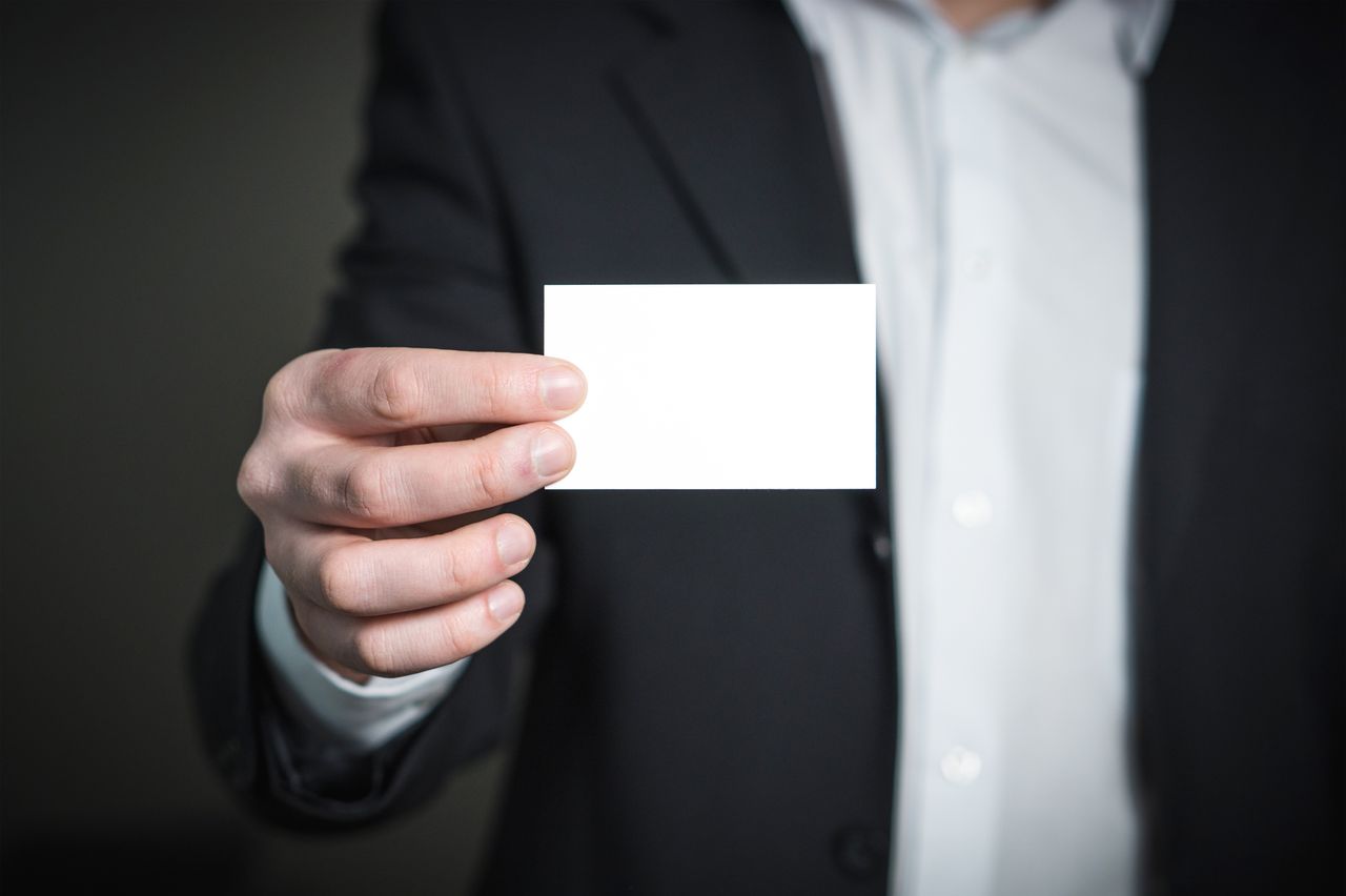 Professional holding a blank business card, ideal for personal branding or business contacts.