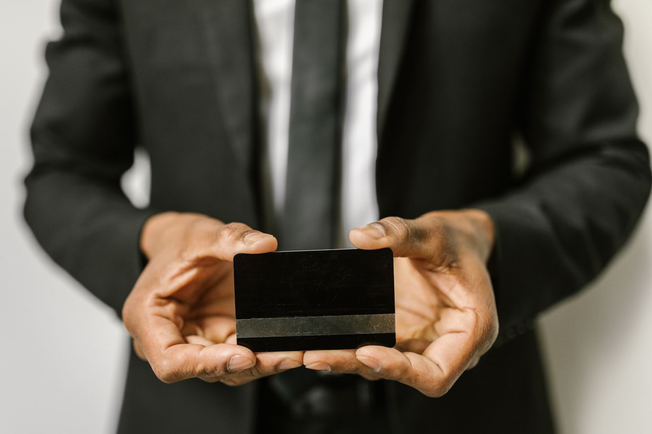 Close-up of a businessman holding a blank credit card with both hands, emphasizing finance.